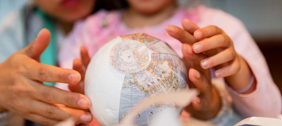 Atelier À 4 mains : Les Globes de Louis XIV - © Emmanuel Nguyen Ngoc / BnF mains d'enfants et de parents construisant des globes de papiers